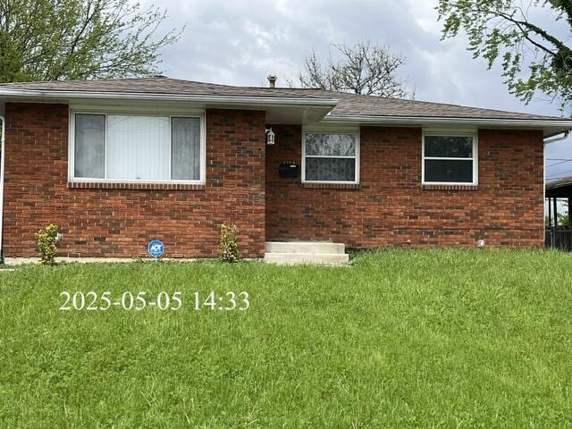 view of front of house with brick siding and a front yard