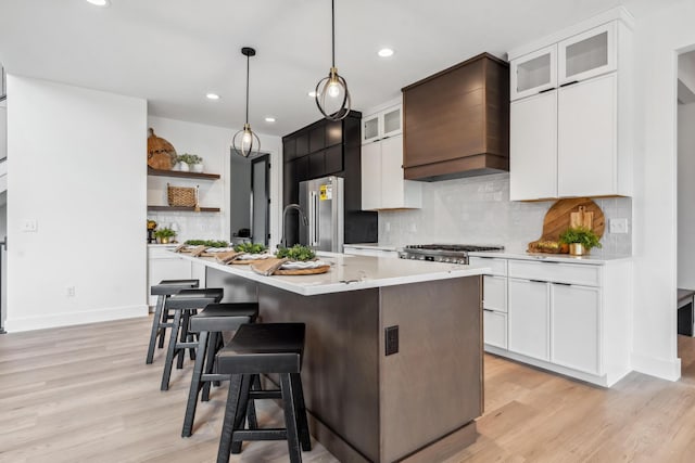 kitchen featuring light wood-style flooring, open shelves, light countertops, custom range hood, and recessed lighting