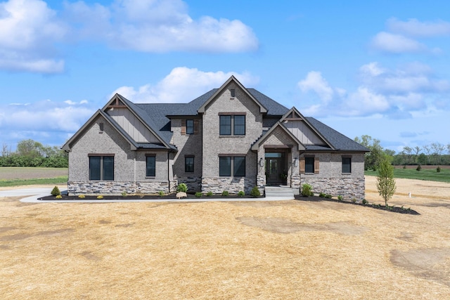 craftsman-style home featuring roof with shingles, stone siding, and board and batten siding