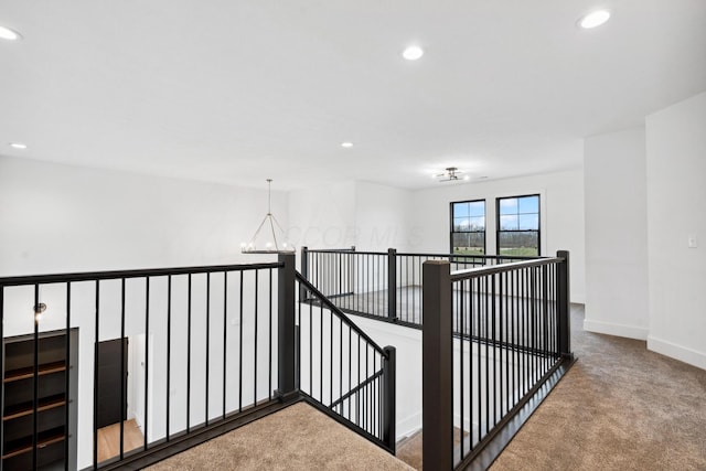 corridor with carpet, baseboards, an upstairs landing, and recessed lighting