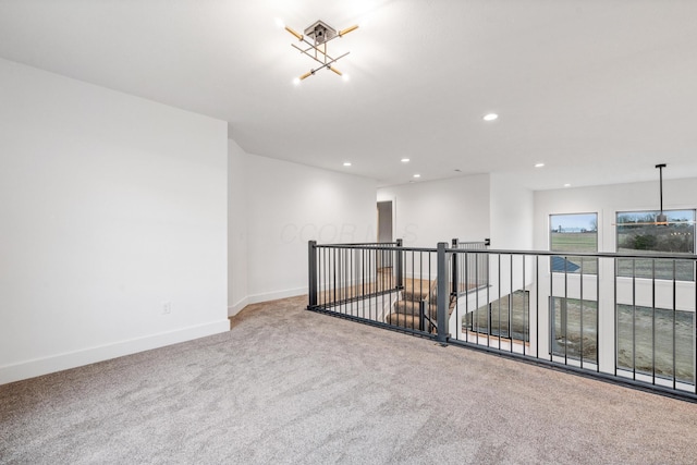 carpeted empty room featuring baseboards and recessed lighting