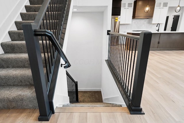 stairway with baseboards and wood finished floors