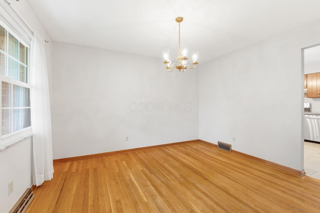 unfurnished room featuring a chandelier, light wood-style flooring, baseboard heating, and baseboards
