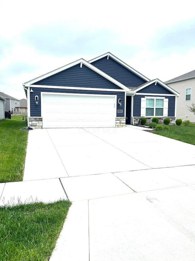 ranch-style house featuring stone siding, an attached garage, driveway, and a front lawn