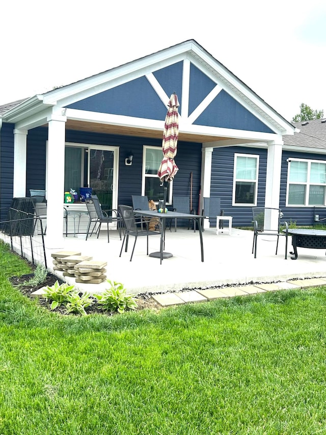 rear view of house with a porch and a lawn