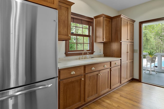 7870 Cook Rd, Plain City, OH 43064 - kitchen featuring freestanding refrigerator, a sink, light countertops, brown cabinets, and light wood finished floors