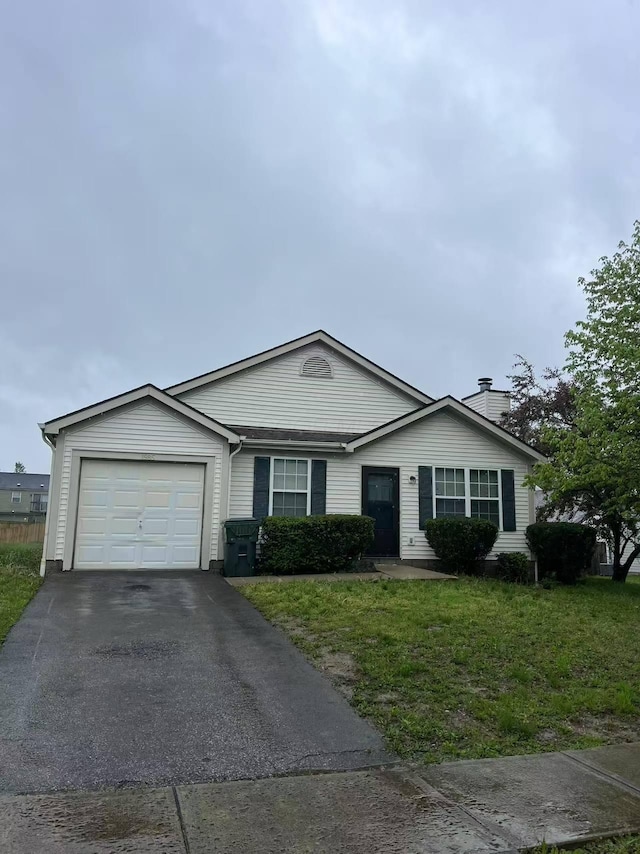 view of front of house featuring an attached garage, driveway, a front lawn, and a chimney