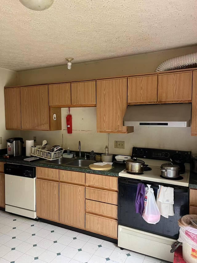 kitchen featuring electric range oven, dishwasher, under cabinet range hood, a sink, and dark countertops