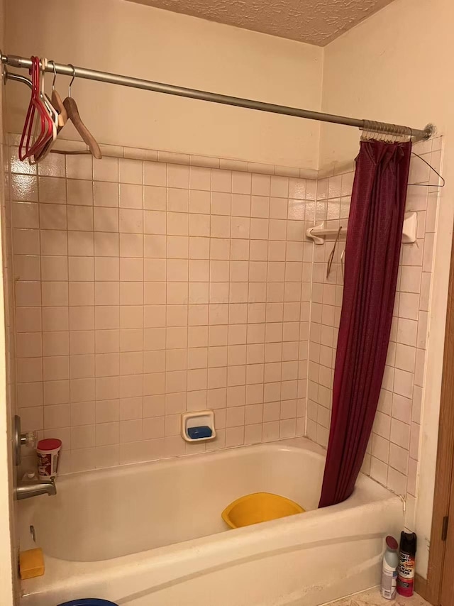 bathroom featuring shower / tub combo and a textured ceiling