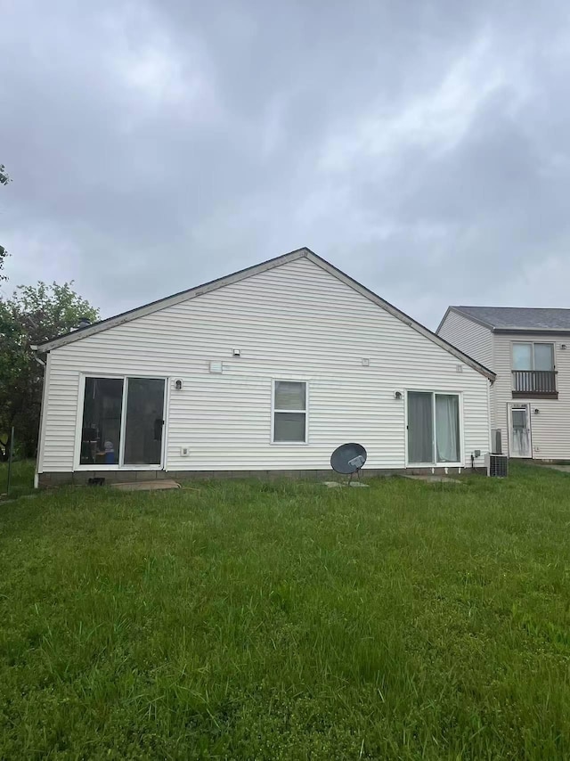 back of house featuring a lawn