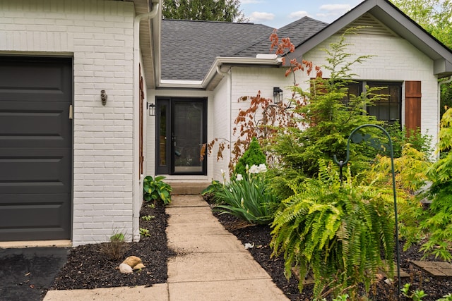 5372 Thistledown Dr, Columbus, OH 43221 - entrance to property featuring brick siding, an attached garage, and a shingled roof