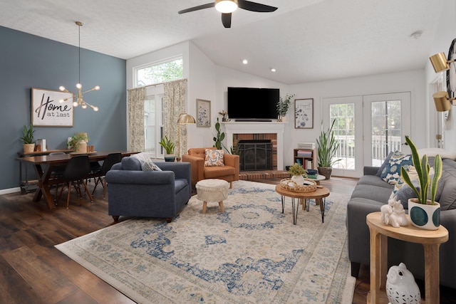 5372 Thistledown Dr, Columbus, OH 43221 - living area featuring healthy amount of natural light, wood finished floors, a brick fireplace, a chandelier, and high vaulted ceiling