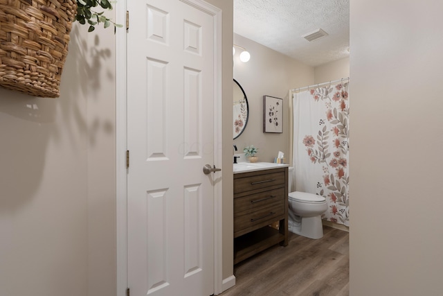 5372 Thistledown Dr, Columbus, OH 43221 - full bathroom with wood finished floors, vanity, toilet, a textured ceiling, and curtained shower