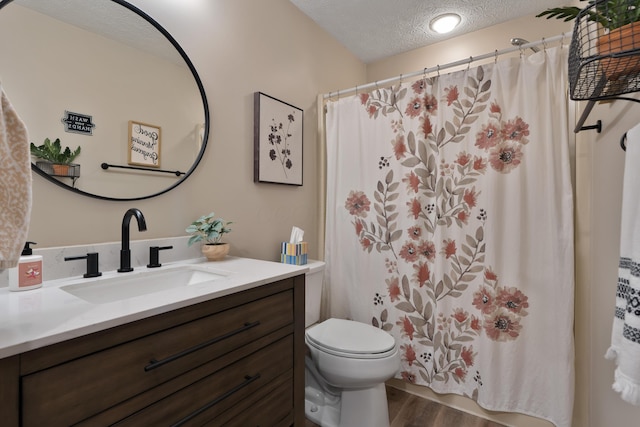 5372 Thistledown Dr, Columbus, OH 43221 - full bath with a textured ceiling, wood finished floors, vanity, toilet, and a shower with curtain