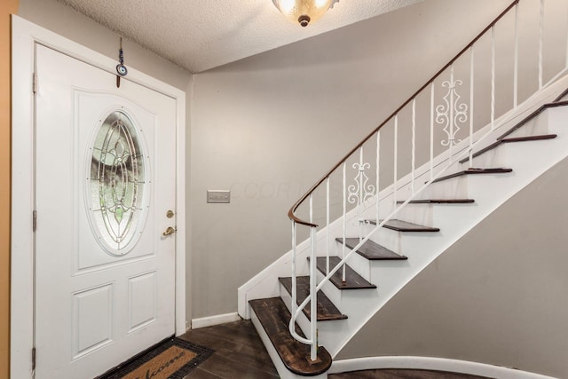 696 Brenton Pl, Columbus, OH 43213 - foyer with baseboards, stairway, a textured ceiling, and dark wood-type flooring