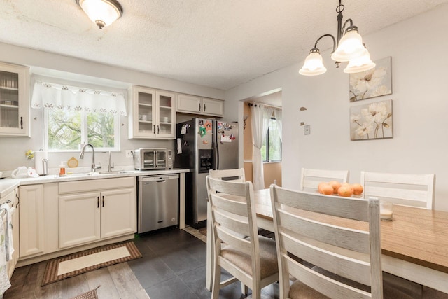 696 Brenton Pl, Columbus, OH 43213 - kitchen with a sink, stainless steel appliances, a textured ceiling, light countertops, and glass insert cabinets