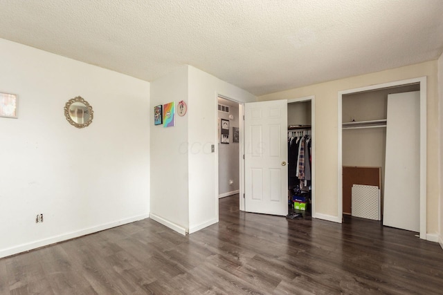 696 Brenton Pl, Columbus, OH 43213 - unfurnished bedroom featuring a textured ceiling, baseboards, visible vents, two closets, and wood finished floors