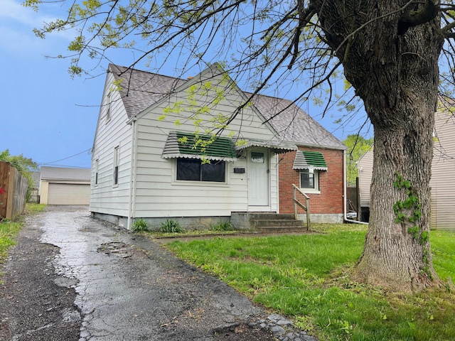 1794 Audrey Rd, Columbus, OH 43224 - view of front of property with roof with shingles, entry steps, an outbuilding, brick siding, and a garage