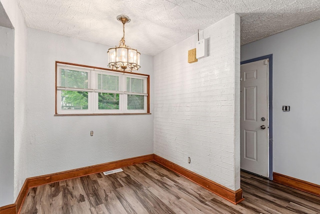 2584 E 5th Ave, Columbus, OH 43219 - unfurnished room with wood finished floors, a chandelier, and a textured ceiling
