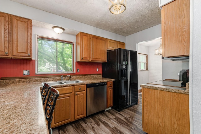 2584 E 5th Ave, Columbus, OH 43219 - kitchen featuring stainless steel dishwasher, black fridge, dark wood-type flooring, brown cabinets, and a textured ceiling