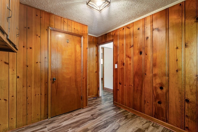 2584 E 5th Ave, Columbus, OH 43219 - corridor featuring wood finished floors, wooden walls, a textured ceiling, and ornamental molding