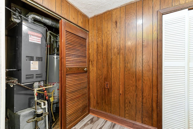 2584 E 5th Ave, Columbus, OH 43219 - hall featuring wooden walls, light wood finished floors, a textured ceiling, heating unit, and water heater