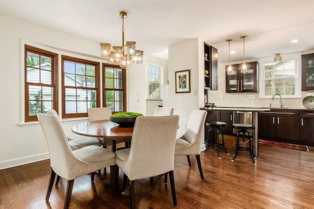 dining area with dark wood finished floors, a chandelier, plenty of natural light, and baseboards
