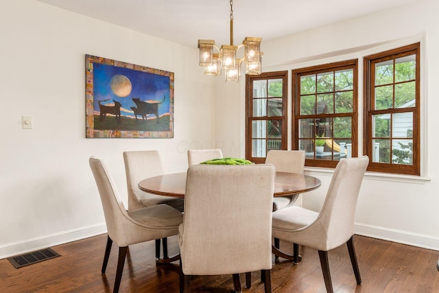 dining area featuring baseboards, dark wood-type flooring, and a chandelier