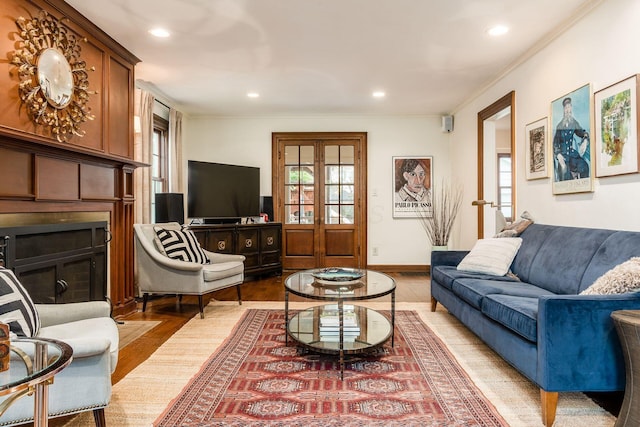 living room featuring a fireplace, crown molding, light wood-style floors, healthy amount of natural light, and recessed lighting
