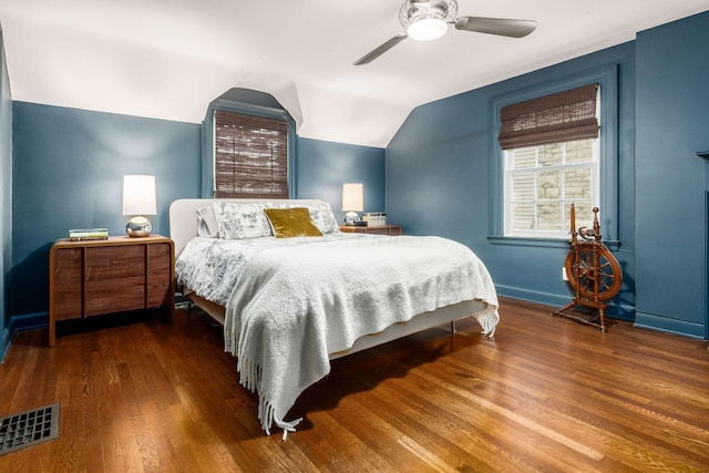 bedroom with wood finished floors, lofted ceiling, baseboards, and ceiling fan