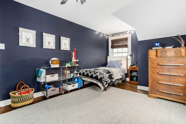 bedroom featuring baseboards, wood finished floors, and a ceiling fan