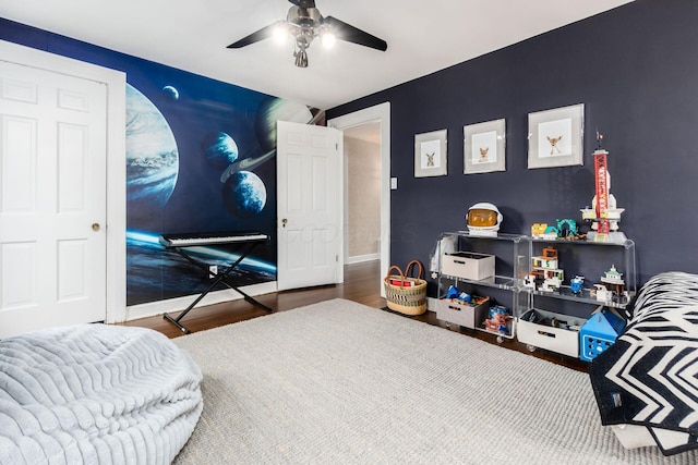 bedroom featuring wood finished floors, a ceiling fan, and baseboards