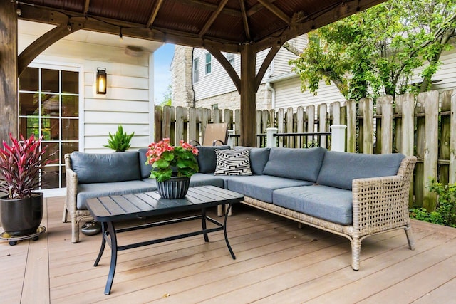 wooden terrace featuring outdoor lounge area and fence