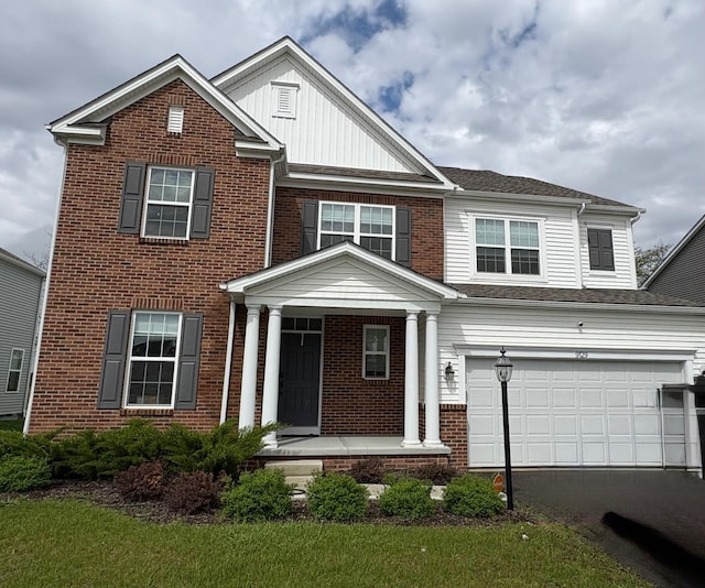 view of front of house with a porch, aphalt driveway, an attached garage, brick siding, and board and batten siding