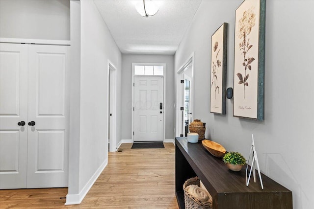 9129 Coe Dr, Plain City, OH 43064 - doorway with light wood-type flooring, baseboards, and a textured ceiling