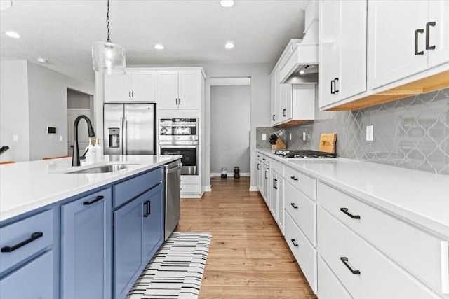 9129 Coe Dr, Plain City, OH 43064 - kitchen featuring stainless steel appliances, blue cabinetry, a sink, light countertops, and recessed lighting