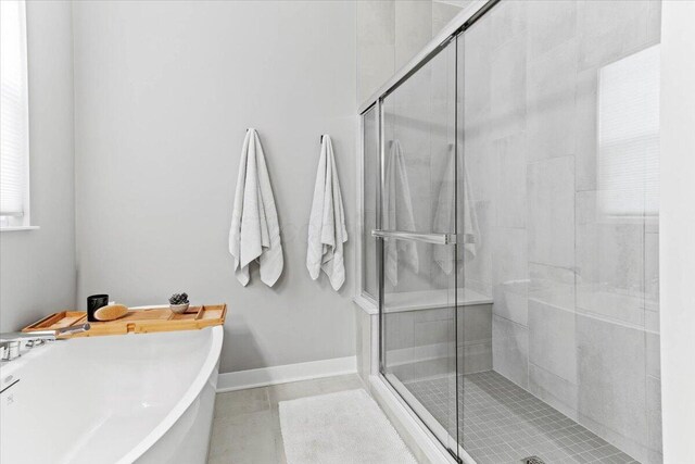 9129 Coe Dr, Plain City, OH 43064 - bathroom featuring a shower stall, a freestanding tub, tile patterned floors, and baseboards