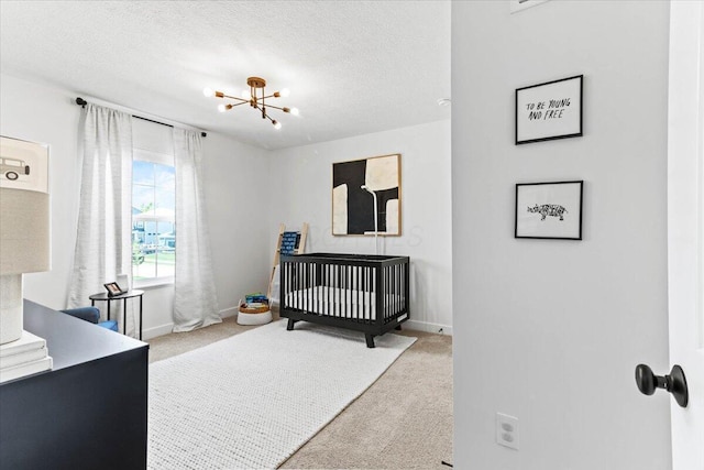 9129 Coe Dr, Plain City, OH 43064 - bedroom featuring carpet, a textured ceiling, a nursery area, baseboards, and a chandelier