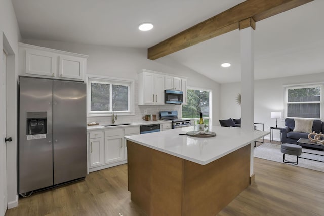 4502 Aragon Ave, Columbus, OH 43227 - kitchen featuring a sink, wood finished floors, stainless steel appliances, tasteful backsplash, and vaulted ceiling with beams