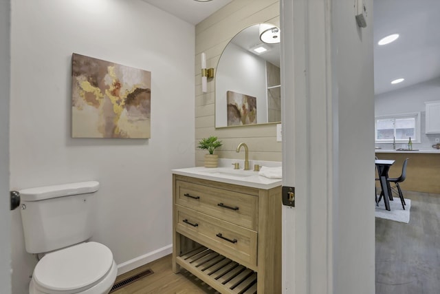 4502 Aragon Ave, Columbus, OH 43227 - bathroom featuring toilet, wood finished floors, visible vents, baseboards, and vanity