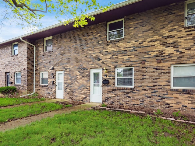 view of front facade with brick siding and a front lawn