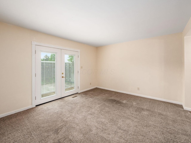 spare room with carpet floors, baseboards, and french doors