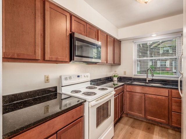 kitchen featuring stainless steel microwave, white electric stove, a sink, light wood-style flooring, and brown cabinets