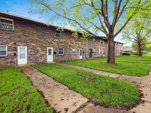 view of property exterior featuring a lawn and brick siding