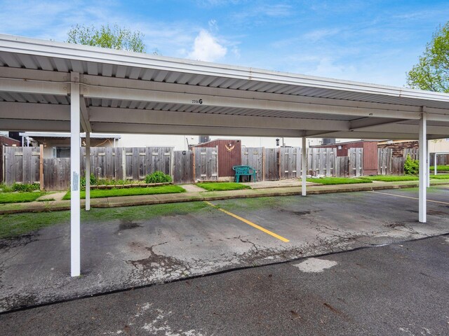 covered parking lot featuring fence