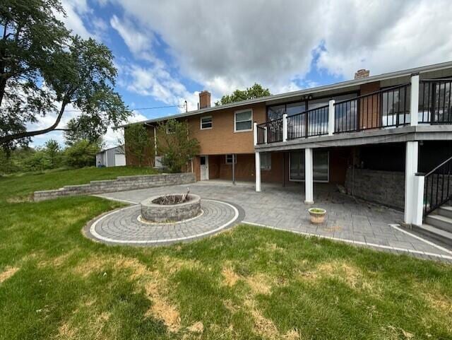 8165 Busey Rd, Pickerington, OH 43147 - back of house with a fire pit, a patio area, a lawn, a chimney, and a deck
