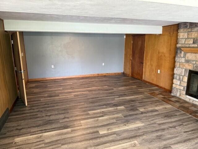 8165 Busey Rd, Pickerington, OH 43147 - unfurnished living room featuring a stone fireplace, wood finished floors, and baseboards