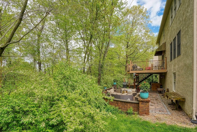 view of yard featuring stairs, a patio, a deck, and outdoor lounge area