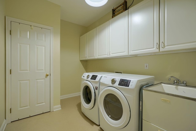 laundry area with washing machine and dryer, a sink, cabinet space, baseboards, and light carpet