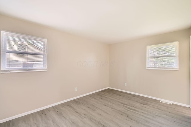 spare room with wood finished floors and baseboards
